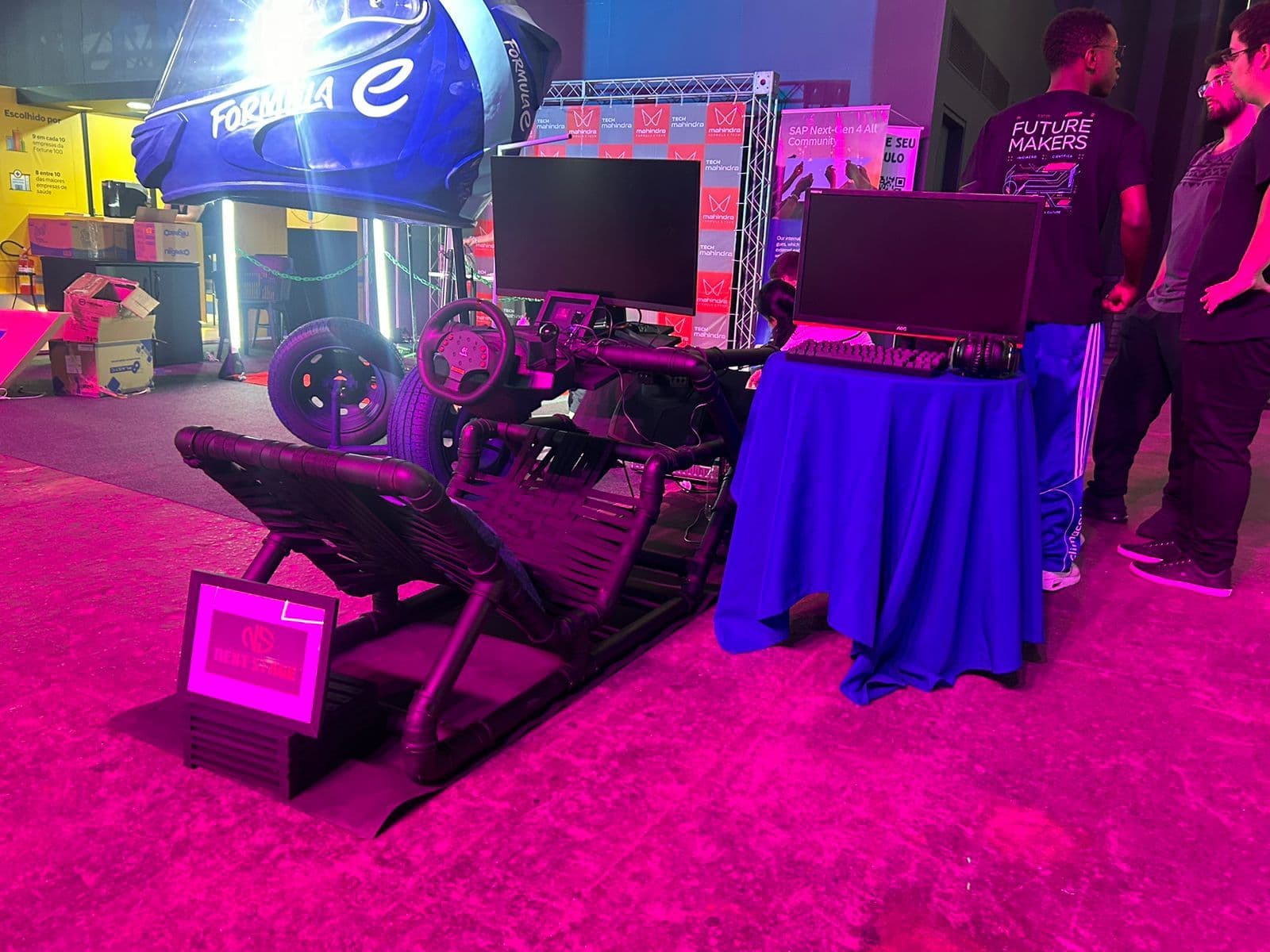Custom telemetry cockpit rig built from black pipe, with a Formula E backdrop